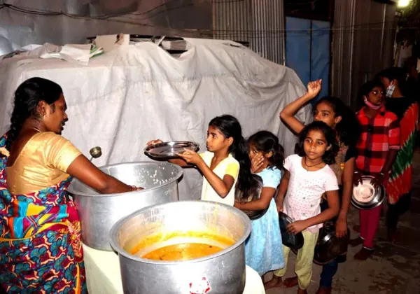 Volunteer serving food to children