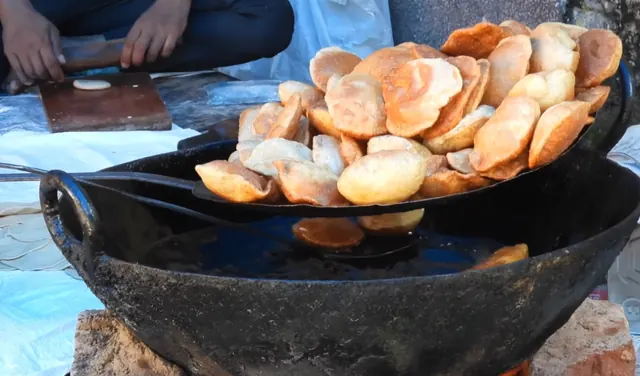 Fresh puris being fried in a kadhai